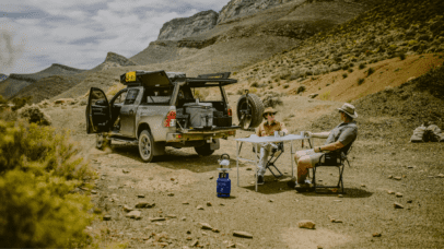 Travelers relaxing beside a BND Car Hire 4x4 in the Namibian wilderness, exemplifying the ease of exploration with reliable rental services.