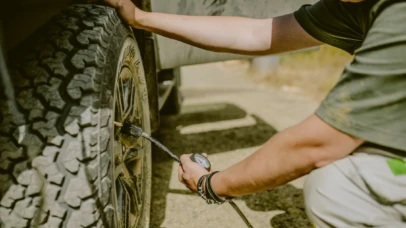 Individual checking tire pressure on a robust off-road rental from BND Car Hire, ensuring vehicle safety for the rugged terrains of Africa.