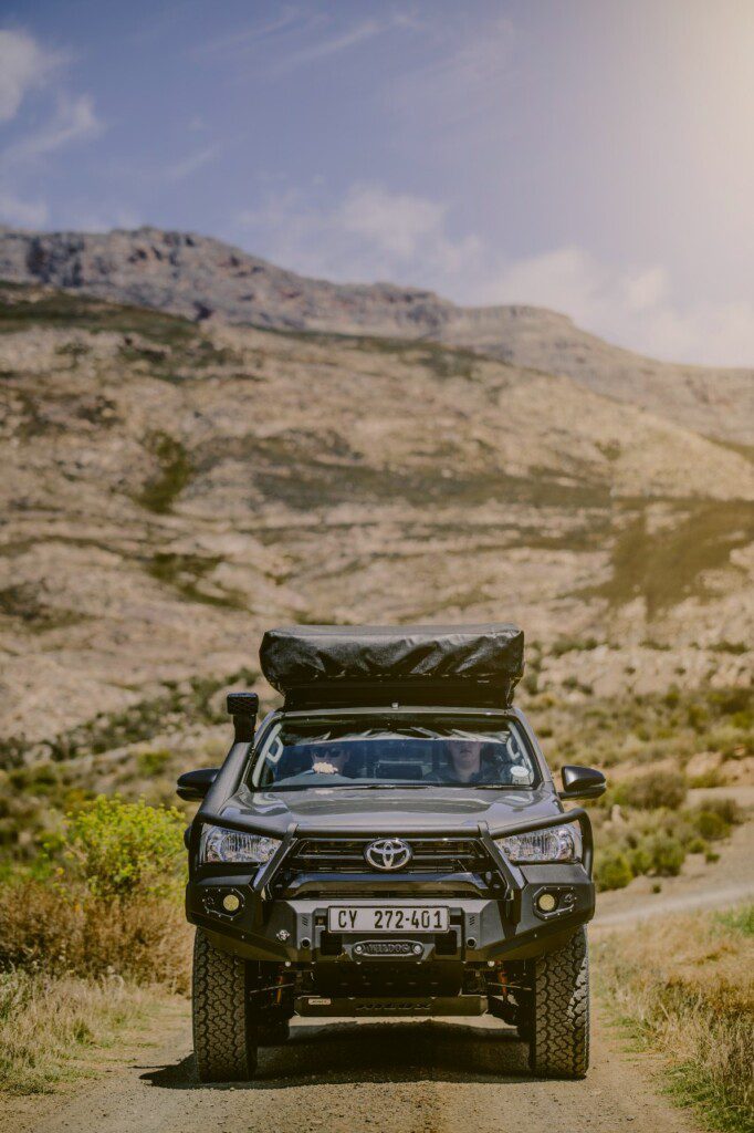 Front view of a Toyota 4x4 with rooftop tent from BND Car Hire, set against the backdrop of Namibia's rugged landscape.