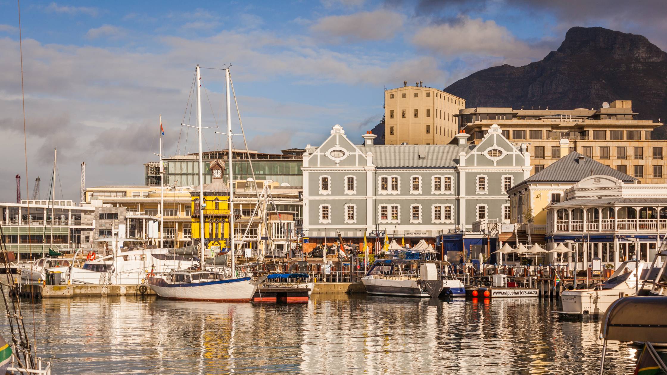 A bustling scene at Cape Town's vibrant waterfront with Table Mountain in the background.