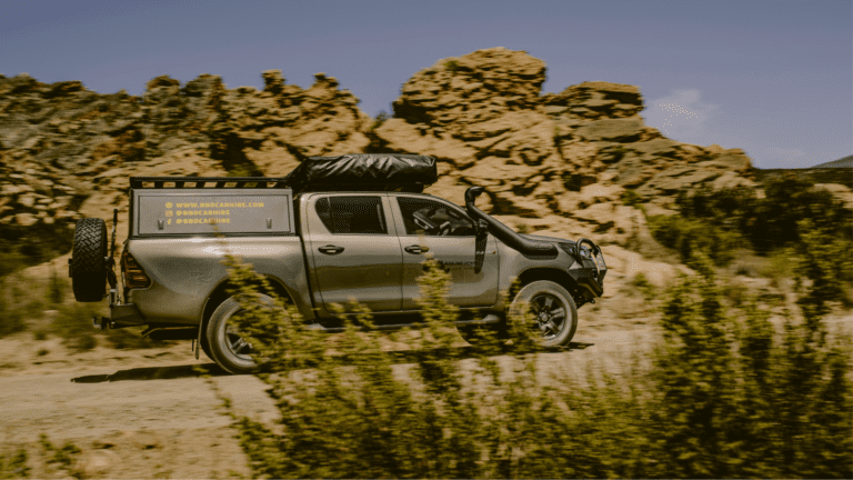 4x4 camper vehicle from Bush and Desert Car Hire navigating a rugged terrain in Namibia.