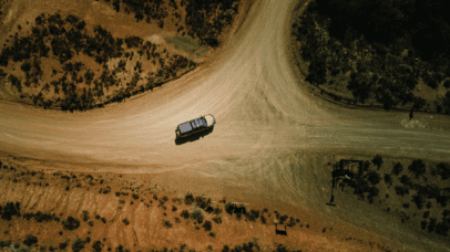 A 4x4 camper navigating a remote dirt road in Namibia, showcasing the rugged terrain ideal for overlanding adventures.