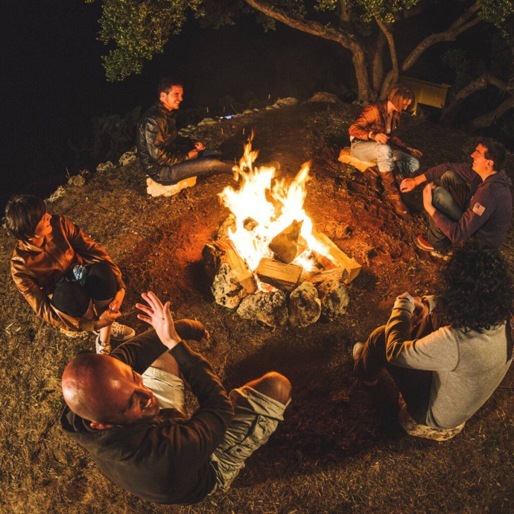 A group of people enjoying a warm campfire in the wilderness of Namibia, ideal for relaxing after a day of exploration with 4x4 hire.