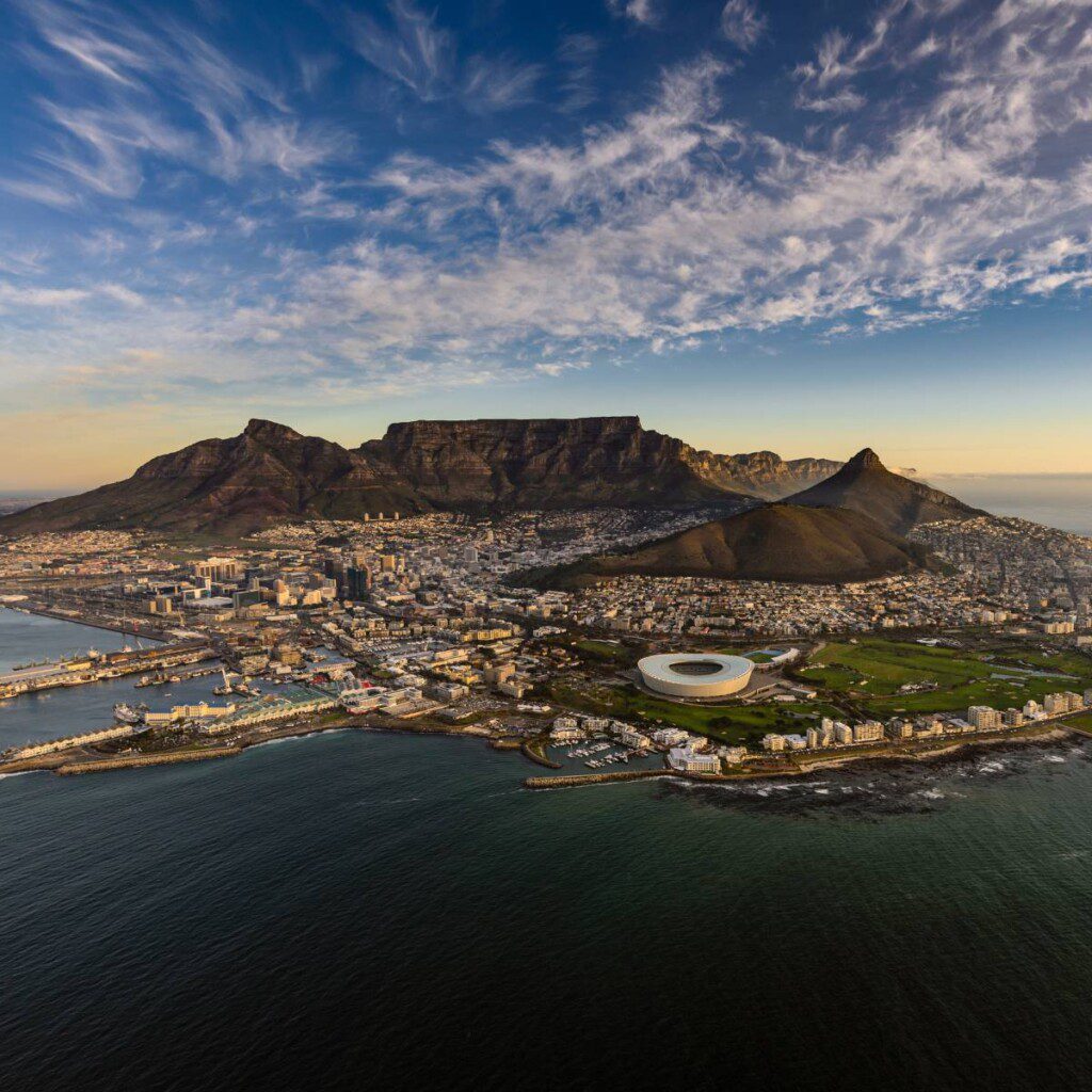 Aerial view of Cape Town with Table Mountain in the background at sunset.