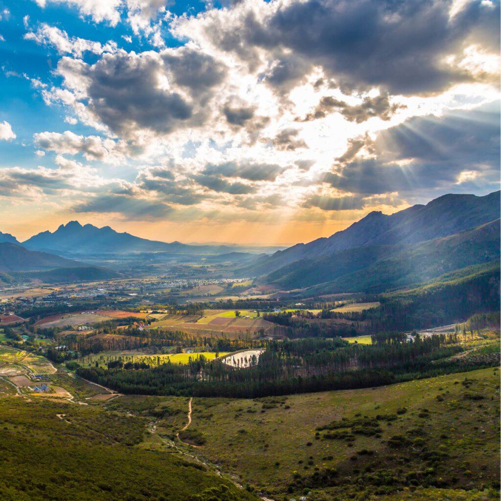 Scenic view of Cape Winelands with vineyards and rolling hills under a dramatic sky