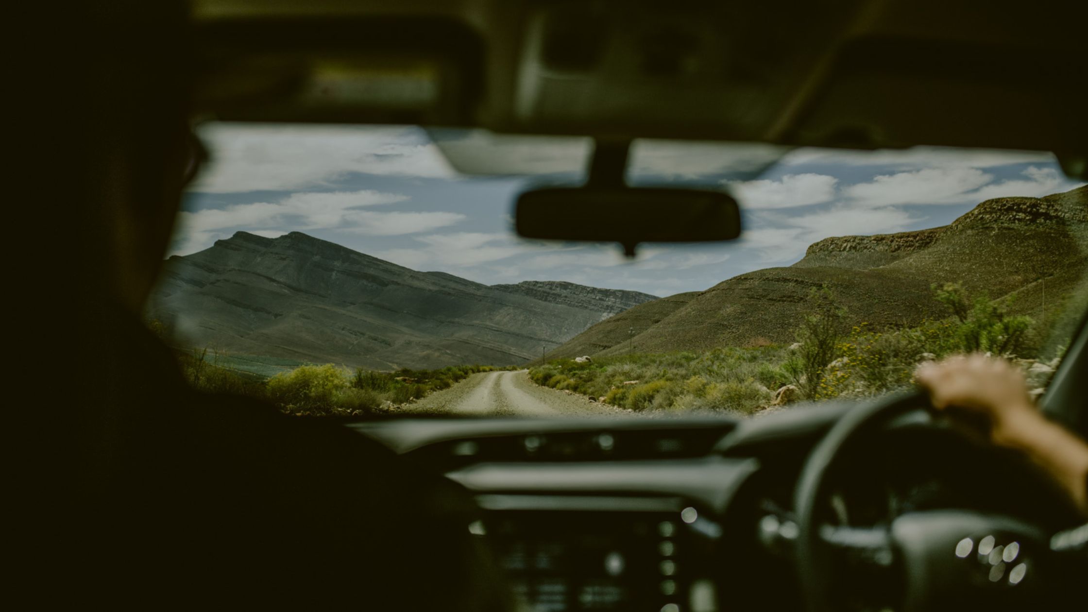 View of a rugged dirt road from inside a vehicle during an overlanding in Africa road trip.