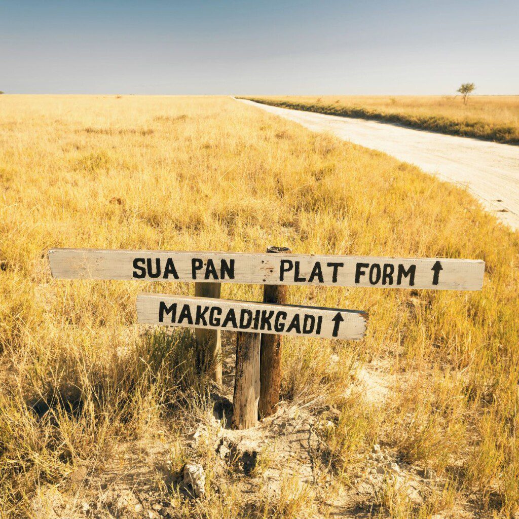 A road sign in the Makgadikgadi Salt Pans, an otherworldly destination accessible via 4x4 car hire in Botswana.